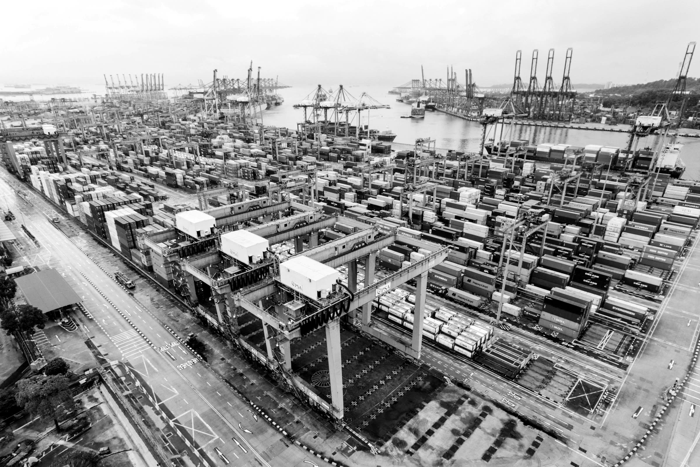 Aerial view of a container terminal with stacked containers and cranes